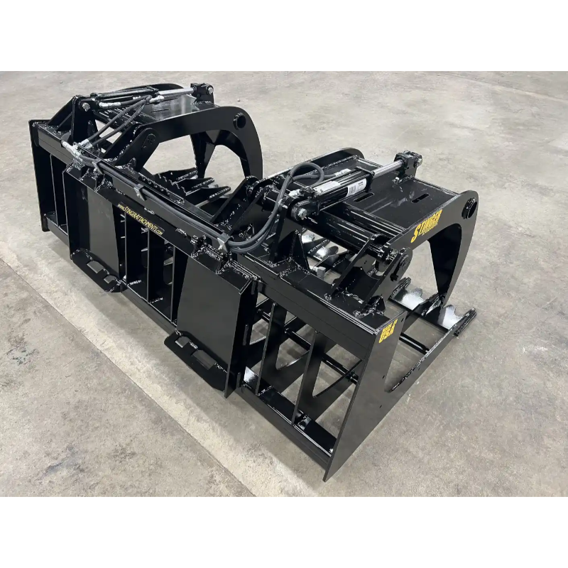 Black skid steer root and rock grapple attachment with dual hydraulic cylinders and reinforced frame on concrete floor