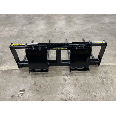 Black steel bale spear skid steer attachment with four pointed tines and mounting brackets viewed from back on concrete floor