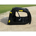 Black skid steer root grapple attachment with curved tines, hydraulic hose, and dual cylinders on dirt and grass background