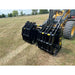 Black steel skid steer grapple attachment with multiple curved tines mounted on yellow loader over dry grass field