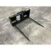 Black steel bale spear attachment with two long pointed tines on concrete floor viewed from front angle