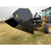 Right side view of black steel hydraulic dump bucket attached to front loader arm on yellow John Deere tractor on grass