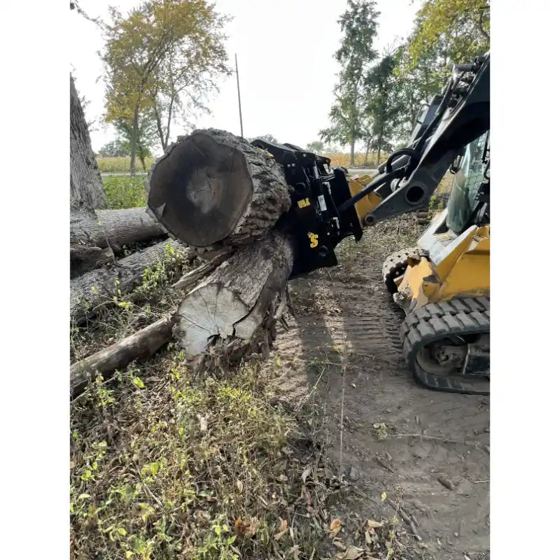 Yellow skid steer loader equipped with black clam grapple attachment lifting large tree logs on dirt surface outdoors