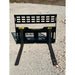 Black steel compact pallet fork attachment with perforated backrest and two extended fork tines on gravel ground outdoors