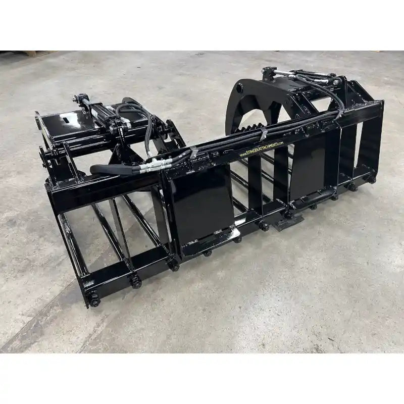 Black metal manure grapple attachment with hydraulic cylinders and reinforced frame on concrete floor indoors