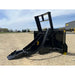 Black steel tree pulling attachment with curved arms and reinforced base resting on gravel surface outdoors