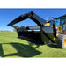 Right-side angled view of tractor with black steel rock bucket reel attachment on green grass under clear blue sky