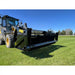 Front-left angled view of tractor with black rock bucket reel attachment on green grassy field under clear blue sky