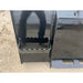 Close-up of metal skid steer bucket with serrated cutting edge and step attachment on dirt surface