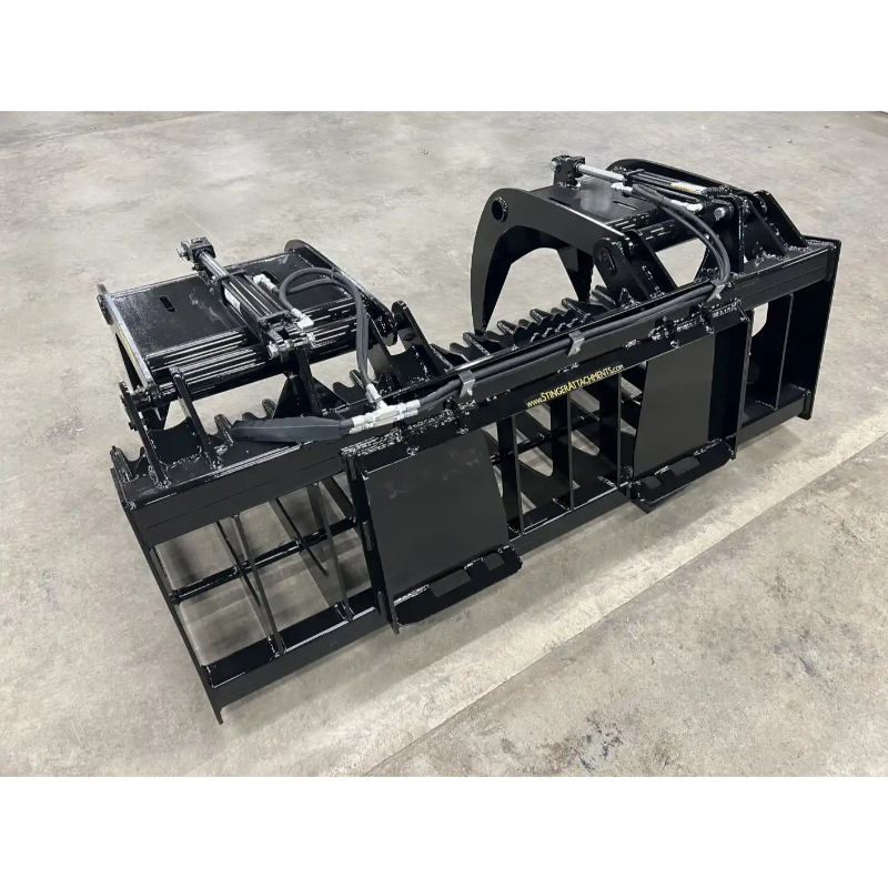 Black steel skid steer root and rock grapple attachment with hydraulic cylinders, reinforced frame, and grid tines on concrete floor