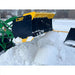 Black and yellow steel snow pusher attachment lifting rolled snow, mounted on green loader in snowy outdoor area