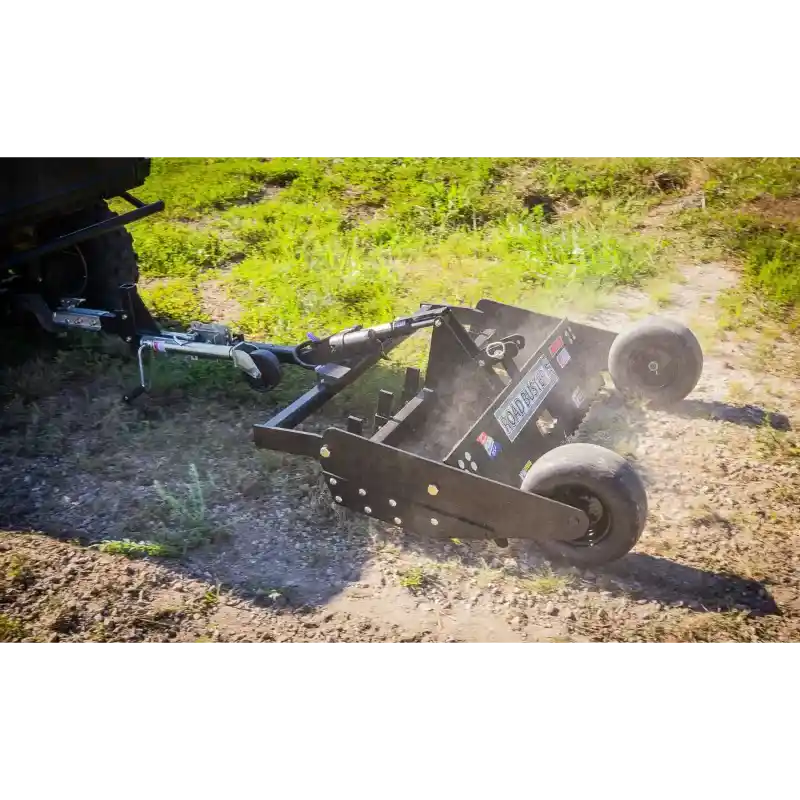 Swisher 48-inch driveway grader connected to ATV, angled side view, grading dirt with ground leveler and dual front wheels, gallery position 1