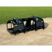 Black steel skid steer root grapple attachment with dual hydraulic arms, curved tines, and mounting brackets on gravel surface