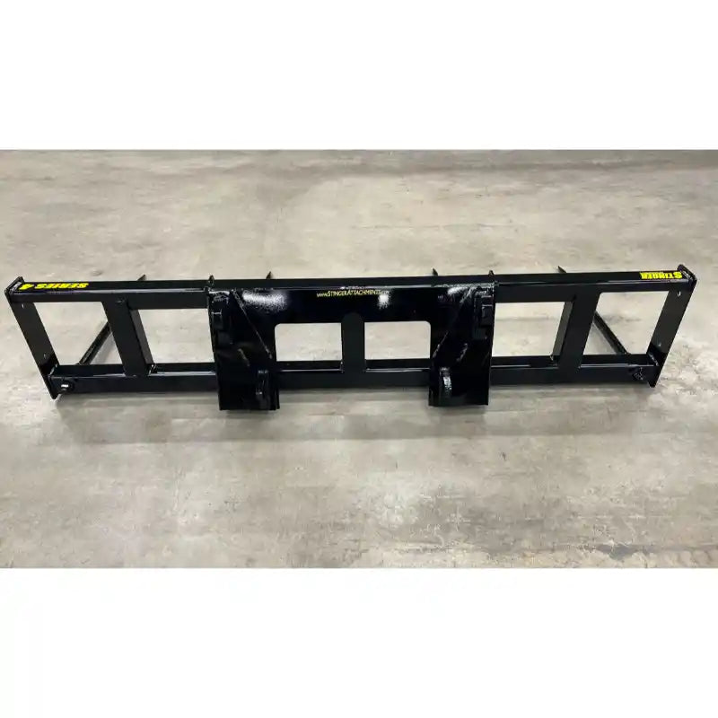 Black metal skid steer attachment frame with mounting brackets on concrete floor