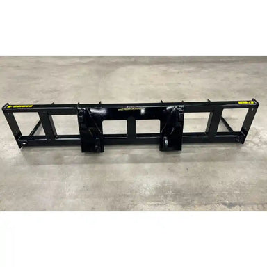 Black steel skid steer attachment frame with mounting brackets on concrete floor viewed from front angle