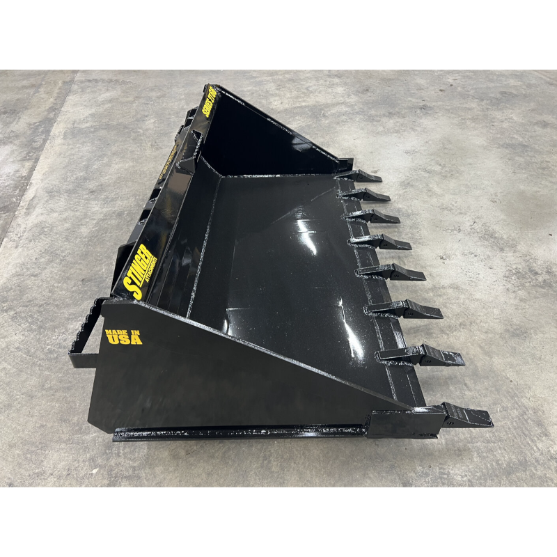 Glossy black loader bucket attachment with eight tapered teeth and reinforced edges on concrete floor