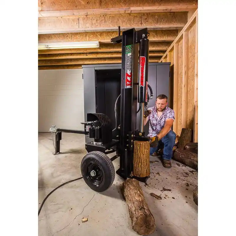 Operator kneeling and positioning log on vertical Swisher 22-Ton Timber Brute Eco Split electric log splitter indoors gallery position 1