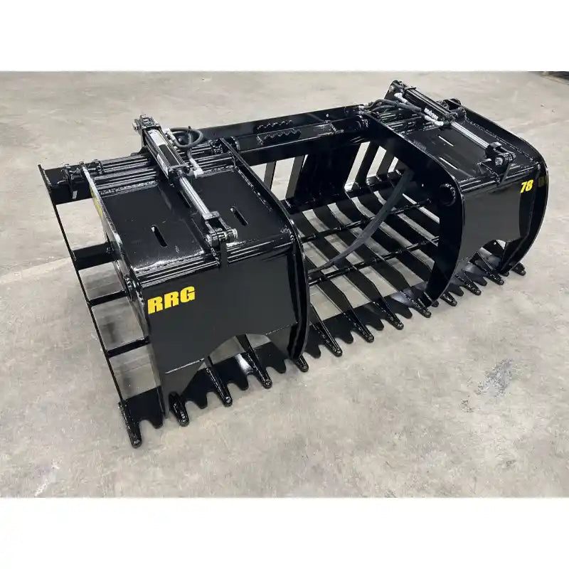 Black steel tractor root and rock grapple attachment with dual hydraulic cylinders and reinforced tines on concrete floor