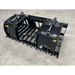 Black steel root and rock grapple skid steer attachment with wide spaced tines and dual hydraulic cylinders on concrete floor