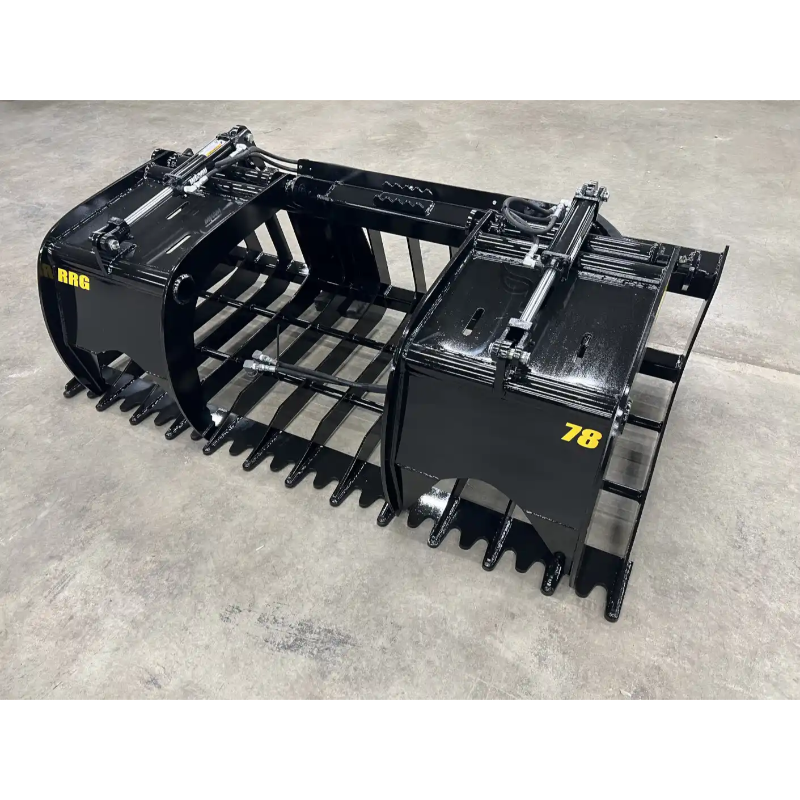 Black steel root and rock grapple skid steer attachment with wide spaced tines and dual hydraulic cylinders on concrete floor