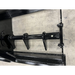 Close-up of black steel auger shaft with welded teeth and mounting brackets on concrete floor surface