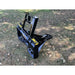 Black steel tractor tree puller attachment with curved arms and solid back frame on grass with scattered leaves