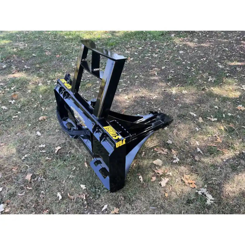 Black steel tractor tree puller attachment with curved arms and solid back frame on grass with scattered leaves