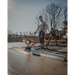 Operator using MBW 501H ScreeDemon gas-powered vibratory wet screed to level freshly poured concrete, gallery position 1