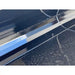 Close-up of smooth black welded metal edge with reflective finish and water droplets on surface