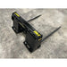 Black steel bale spear attachment with two long pointed tines on concrete floor viewed from back right angle
