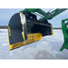 Black and yellow steel snow pusher attachment mounted on green loader arm over snowy ground with some snow on blade edges