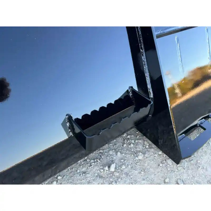 Close-up of a black metal step with serrated edge mounted on a glossy steel tractor bucket attachment outdoors