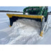 Yellow and black steel snow pusher attachment clearing packed snow mounted on green tractor on snowy field