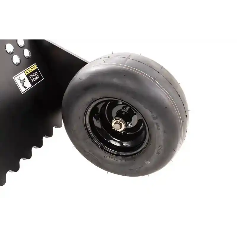 Close-up of smooth tire mounted on black rim with serrated blade edge and caution label, Swisher 48" Driveway Grader, gallery 1