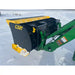 Black and yellow compact snow pusher attachment mounted on green skid steer loader arm in snowy environment