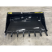 Glossy black steel skid steer bucket attachment with eight cutting teeth labeled Stinger Series 2T66 on concrete floor