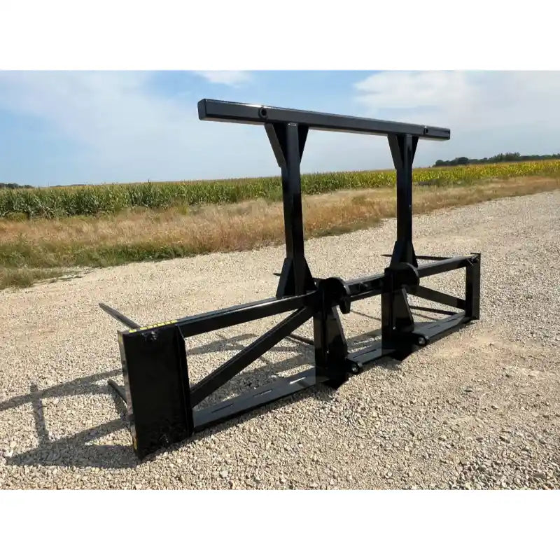 Black painted steel skid steer attachment with dual vertical supports and horizontal crossbar on gravel surface outdoors