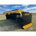 Black and yellow steel snow pusher attachment with reinforced cutting edge and mounting brackets on grass field