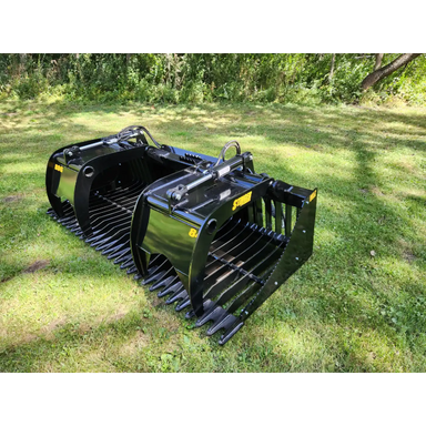Black steel skid steer grapple attachment with spaced curved tines, hydraulic arms, and reinforced side plates on grass outdoors