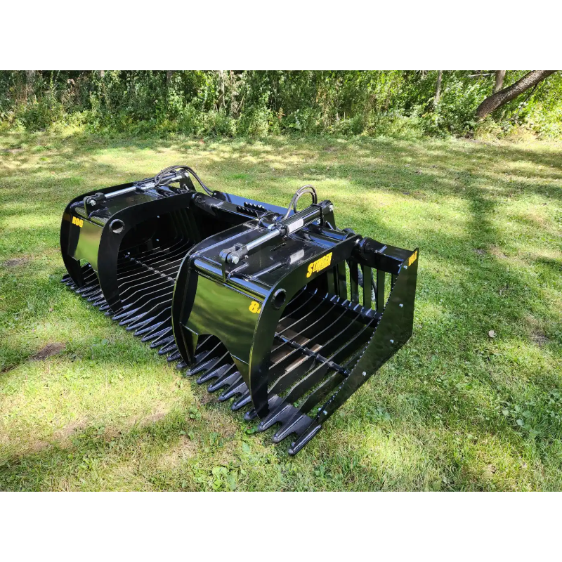 Black steel skid steer grapple attachment with spaced curved tines, hydraulic arms, and reinforced side plates on grass outdoors