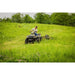ATV towing Swisher 44" Rough Cut Brush Mower across overgrown field, gallery position 1
