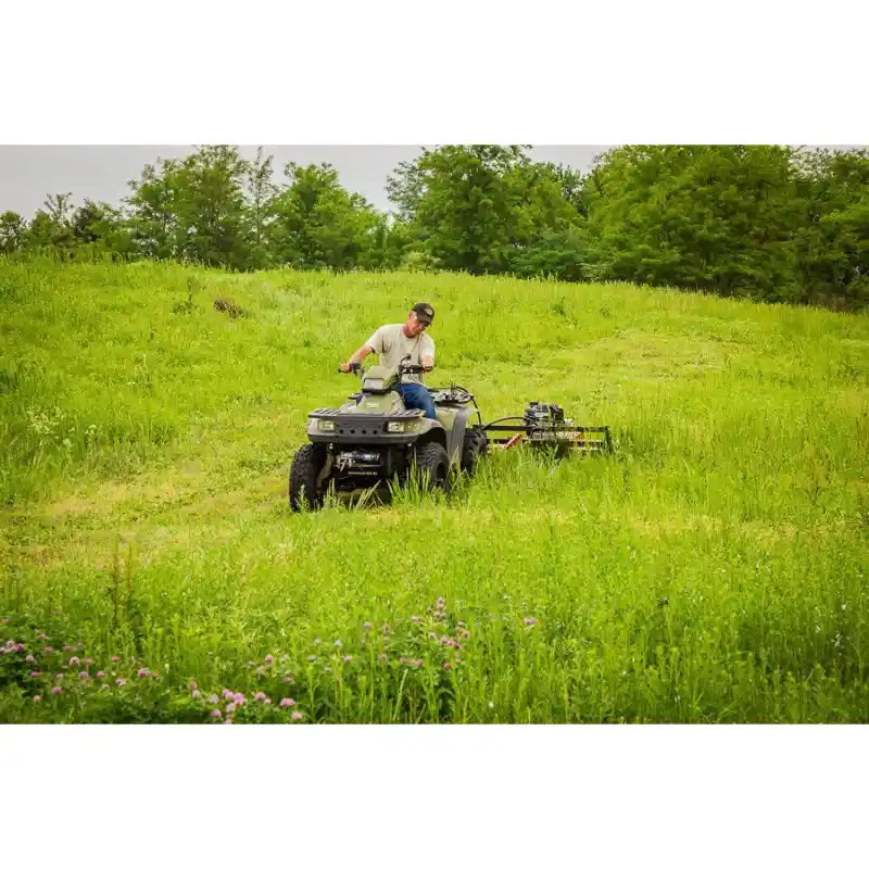 ATV towing Swisher 44" Rough Cut Brush Mower across overgrown field, gallery position 1