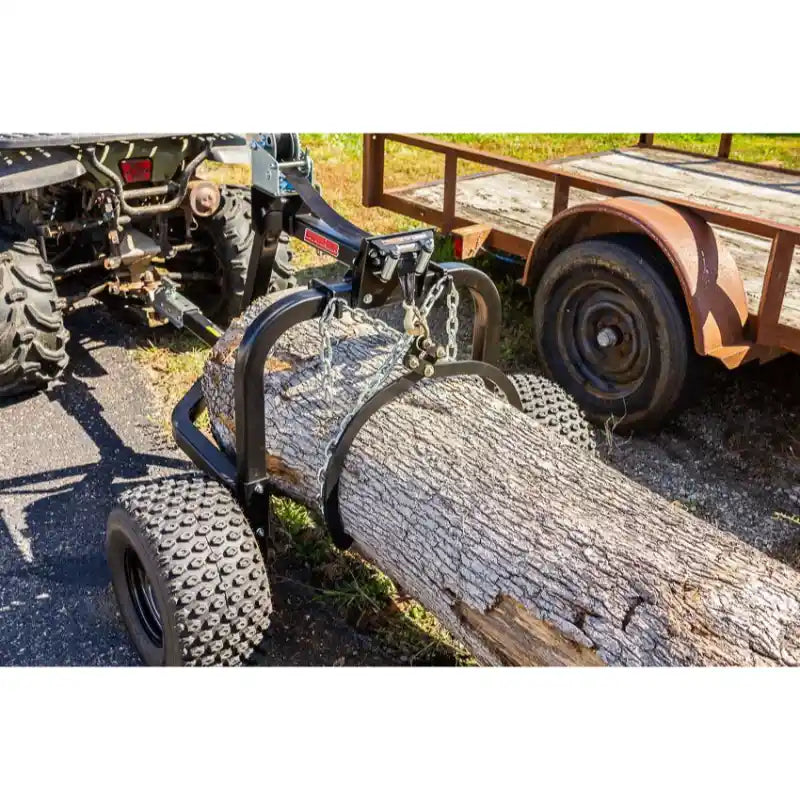Close-up of Swisher ATV Log Skidder lifting large log with welded steel frame and knobby tires, gallery position 1
