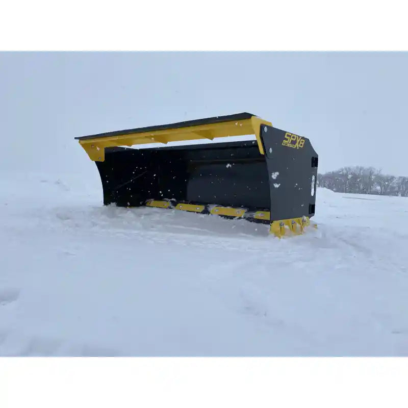 Angled side view of black and yellow skid steer snow pusher attachment resting on snow-covered ground outdoors