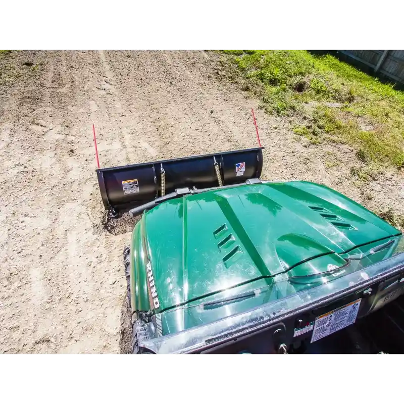 Overhead view of green utility vehicle fitted with Swisher 62-inch plow rolled blade on soil surface, gallery position 1