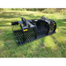 Black steel skid steer rock grapple attachment with wide spaced tines, hydraulic linkage, and reinforced side panels on grass outdoors