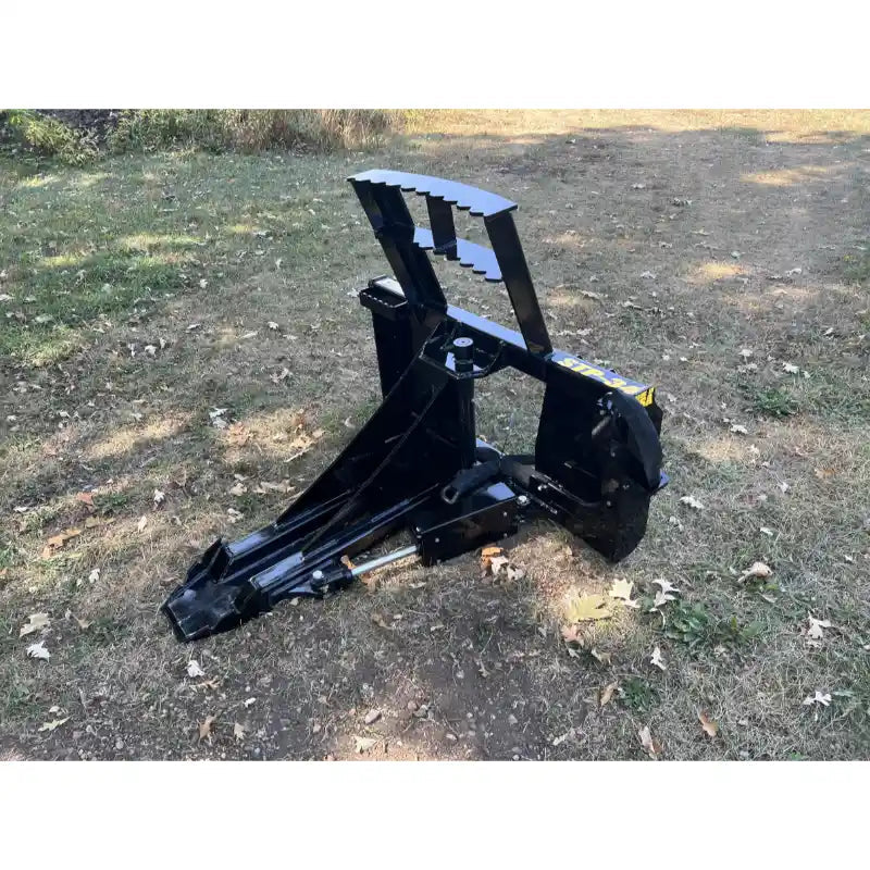 Black steel tractor-mounted tree puller attachment with serrated gripping teeth and hydraulic cylinders on grass surface