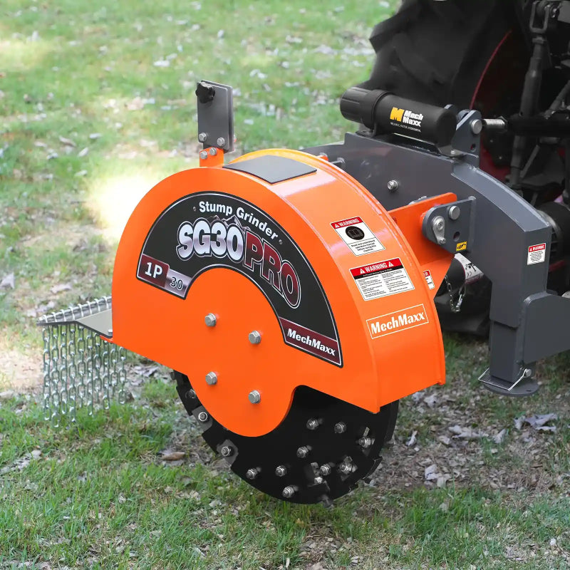 side angle of orange MechMaxx SG30PRO stump grinder with carbide teeth attached to tractor 3-point hitch at gallery 1