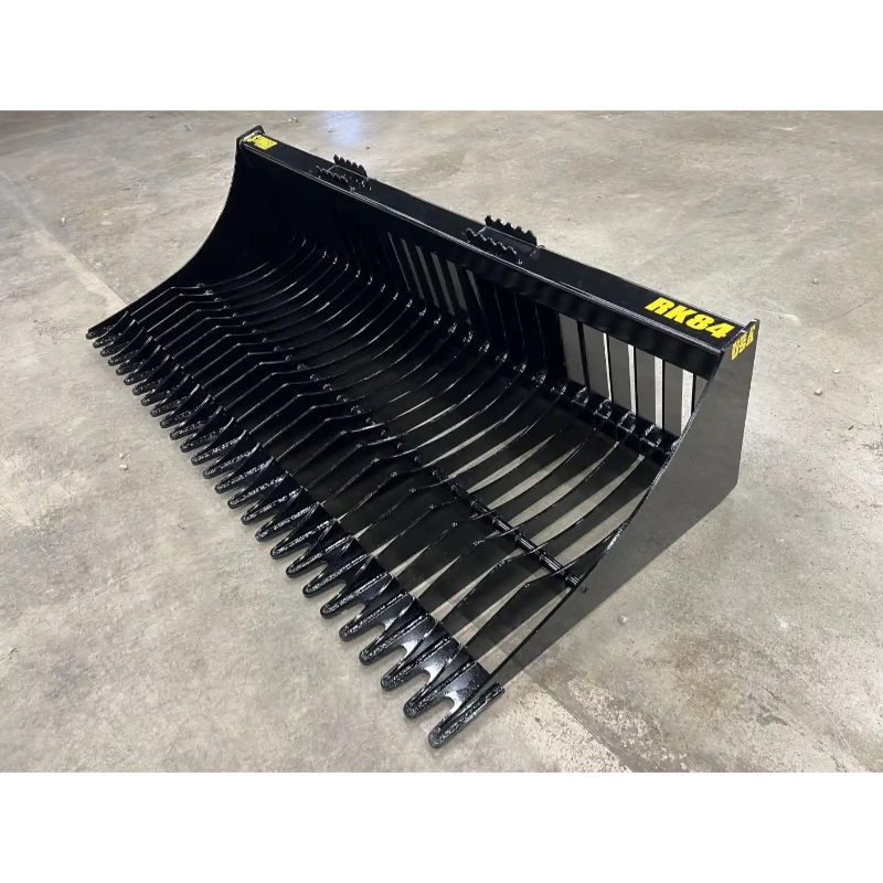 Left angled view of black metal skid steer rock bucket attachment with widely spaced curved tines and reinforced mounting plate on concrete floor