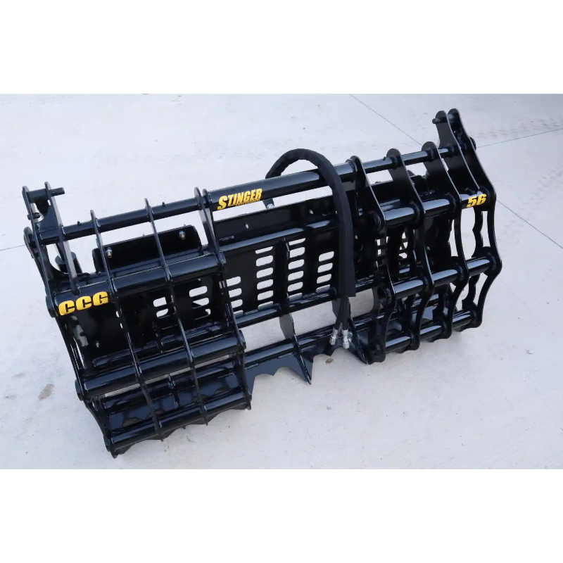 Black steel compact clam grapple attachment with hydraulic hose and mounting brackets on concrete surface outdoors